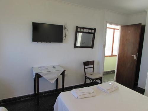 una stanza con un letto, un tavolo e uno specchio di Hotel Brisas del Mar a Miramar