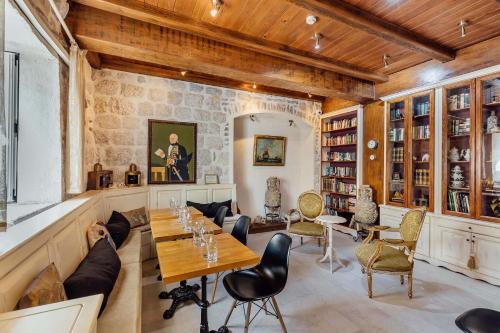 a room with a table and chairs and a stone wall at Palazzo Radomiri Heritage Boutique Hotel in Kotor