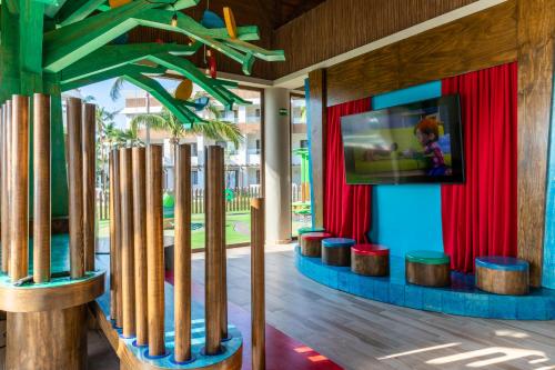 a room with red curtains and a tv on a wall at Bahia Principe Grand Tulum - All Inclusive in Akumal