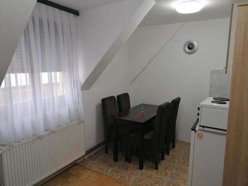 a dining room table with black chairs in a kitchen at Apartments Vila Djurdja in Kopaonik