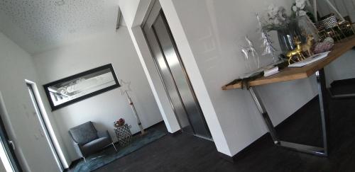 a hallway with a silver refrigerator in a room at Haidinger's Boutique Domizil in Oftering