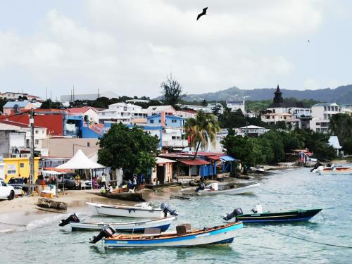 a group of boats in the water next to a town at Résidence B&L Lagon : Bungalow Atoll in Sainte-Luce