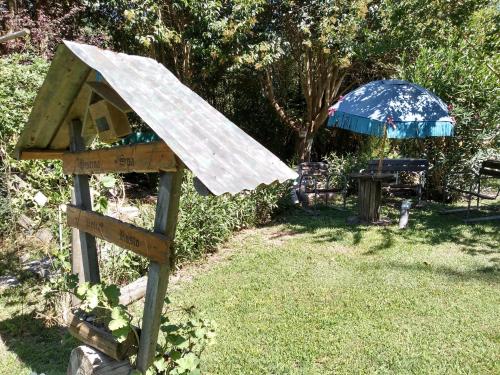 a wooden bird house sitting in the grass at Pualy Resort & Spa in Belén de Escobar