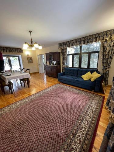 a living room with a blue couch and a table at Willa nad Pilicą in Promna