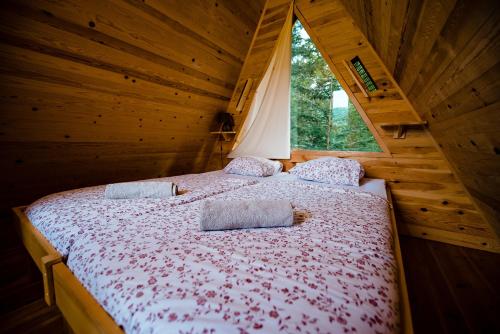 1 dormitorio con 1 cama en una cabaña de madera en Glamping FOREST EDGE, en Kamnik