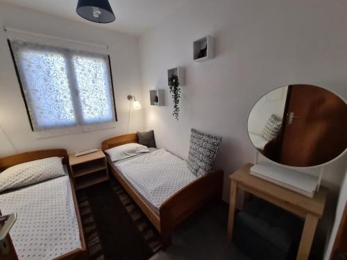 a small room with a bed and a mirror at Apartmani Bellevue in Vir