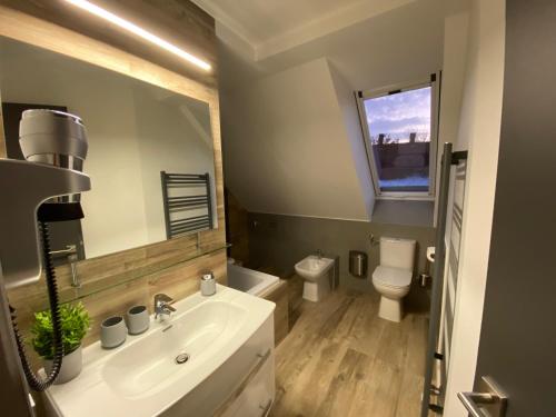 a bathroom with a sink and a toilet and a mirror at Minaret Residence & Relax Pécs in Pécs