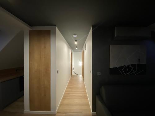 a hallway of a house with black walls and wooden floors at Minaret Residence & Relax Pécs in Pécs