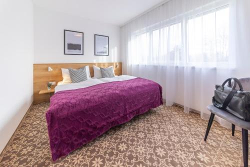 a bedroom with a bed with a purple blanket at Haidinger's Boutique Domizil in Oftering