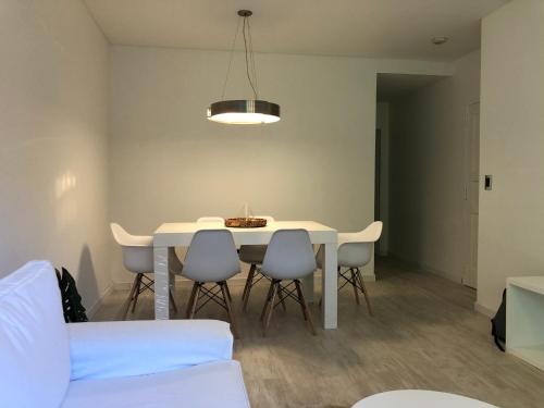 une salle à manger avec une table et des chaises blanches dans l'établissement Excelente departamento de 2 ambientes en palermo, à Buenos Aires