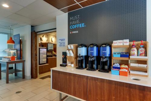 a coffee shop with a counter with bottles on it at Holiday Inn Express - Cincinnati North - Monroe by IHG in Monroe