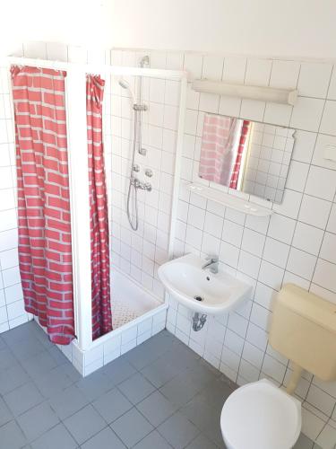 a bathroom with a sink and a shower and a toilet at Sio Hostel in Siófok