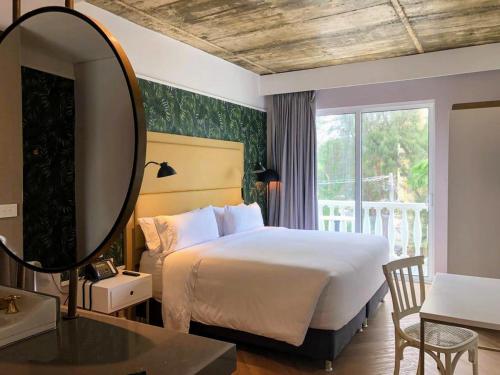 a bedroom with a large bed and a mirror at Faranda Collection Barranquilla, a member of Radisson Individuals in Barranquilla