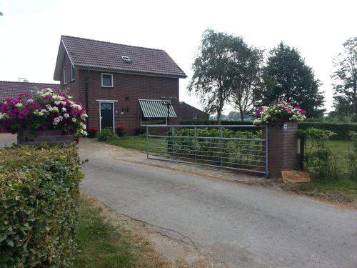 a house with a gate and a house with flowers at B&B de Rivierduin in Hattem