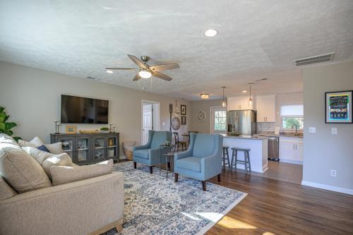 a living room with a couch and chairs and a kitchen at Ranch Style Home & Plenty Of BKYD Space Near KSU in Marietta