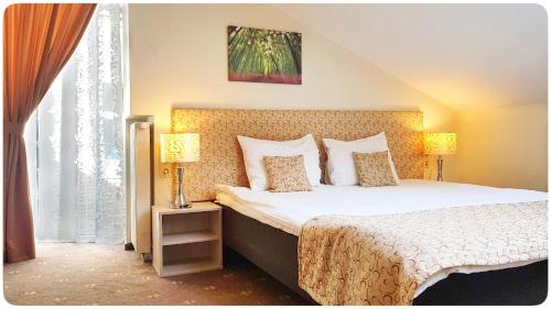 a bedroom with a large bed with two lamps at Vivulskio Apart-Hotel in Vilnius