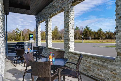a patio with tables and chairs and a parking lot at Candlewood Suites - Kingston West by IHG in Kingston