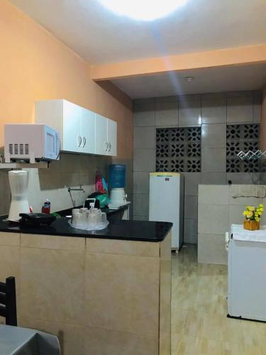 a kitchen with a counter and a white refrigerator at Casa de Veraneio Ilha de Itamaracá in Itamaracá