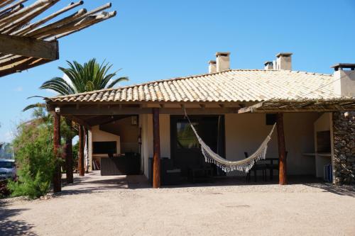 a house with a hammock hanging from it at Complejo Aguazul in La Pedrera