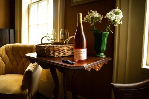 a bottle of wine and a basket of flowers on a table at Black Walnut Bed and Breakfast in Interlaken