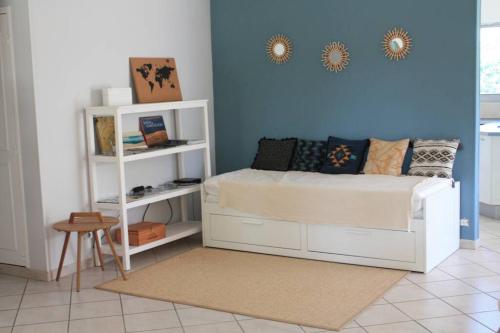 een slaapkamer met een wit bed en een blauwe muur bij Grande maison familiale piscine et jardin in Gujan-Mestras
