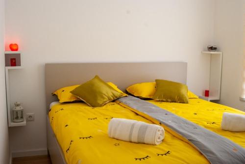 ein Schlafzimmer mit einem gelben Bett mit Vögeln darauf in der Unterkunft Apartman Amor in Tuzla