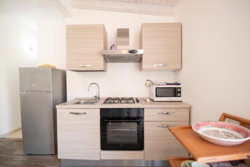 a small kitchen with a stove and a refrigerator at Holiday Fontane Bianche Gabriella in Fontane Bianche