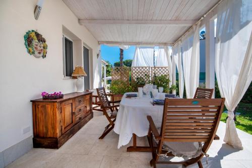a dining room with a table and chairs on a patio at Holiday Fontane Bianche Gabriella in Fontane Bianche
