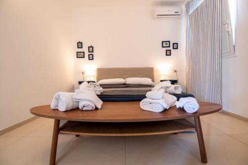 a room with towels on a table with a bed at Holiday Fontane Bianche Gabriella in Fontane Bianche