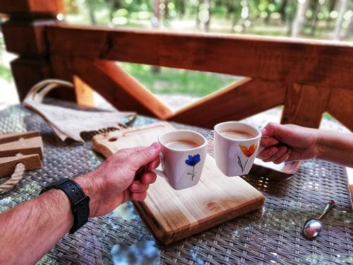 two people holding cups of coffee on a table at Łosia Chata in Grzybowce