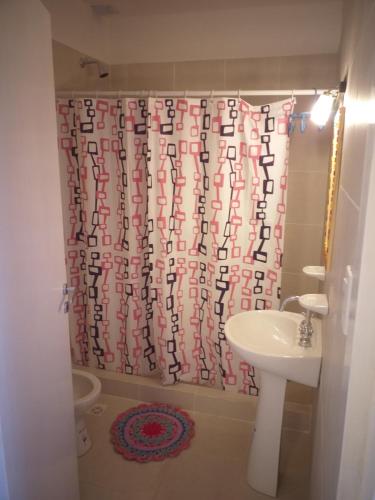 un bagno con tenda da doccia e lavandino di Abuela Mari Apart Cabaña a Villa Cura Brochero