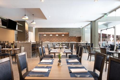 a dining room with wooden tables and chairs at Crowne Plaza San Jose La Sabana by IHG in San José