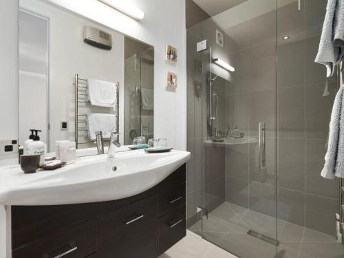 a bathroom with a white sink and a shower at Lake Avenue Studio in Queenstown