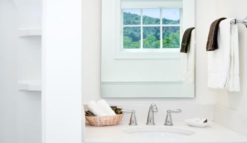 a bathroom sink with a mirror and a window at The Shire Woodstock in Woodstock