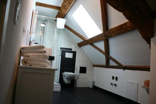 a bathroom with a toilet and a ceiling with beams at Lechwirt in Schongau