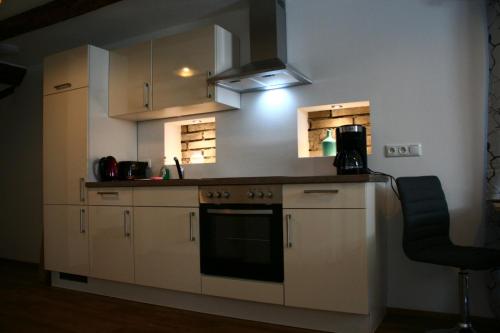 雄高的住宿－Lechwirt，厨房配有白色橱柜和炉灶烤箱。