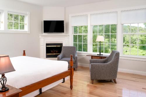 a bedroom with a bed and two chairs and a fireplace at The Shire Woodstock in Woodstock