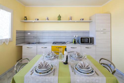 a kitchen with a table with dishes on it at Borgo dell'Uccellaia - Turchese - Giada in Marciana Marina