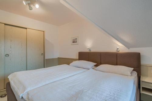 ein Schlafzimmer mit einem großen weißen Bett mit zwei Kissen in der Unterkunft Schmiedestrasse 3 Wohnung 7 in Scharbeutz