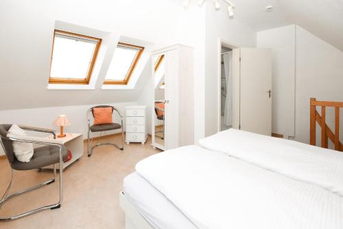 um quarto com uma cama, uma secretária e uma cadeira em Sperlingslust em Scharbeutz