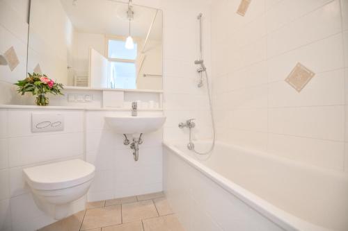een witte badkamer met een toilet en een wastafel bij Terrassenhügel App 106 in Scharbeutz