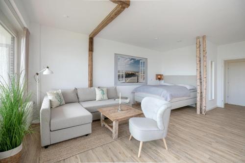 uma sala de estar com um sofá e uma cama em Haus Bellevue Stuuv 8 em Scharbeutz