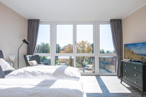 een slaapkamer met een bed en een groot raam bij Wohnung 8, Strandnah in Sierksdorf