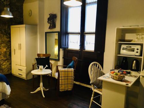 uma pequena cozinha com uma mesa e uma pequena mesa em Estudio Taller de Tejas Colonia B&B em Colônia do Sacramento