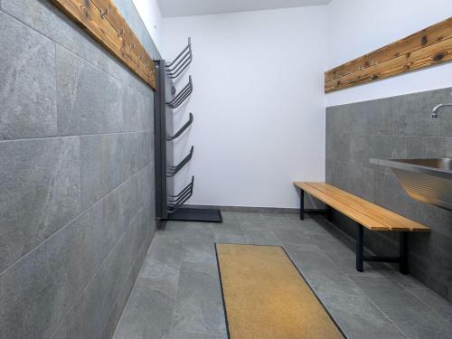 ein Badezimmer mit einem Waschbecken und einer Bank in der Unterkunft Luxury chalet with 3 bathrooms, near a small slope in Neukirchen am Großvenediger