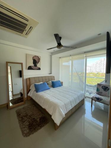 una camera con un grande letto e uno specchio di Apartamento VISTA AL MAR PLAYA DORMIDA 2 - por MESES POZOS COLORADOS a Santa Marta