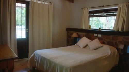 1 dormitorio con 1 cama blanca grande y ventana en La Farfalla en La Población