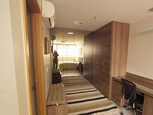 a hallway with a room with a bed and a desk at Duplex Apto Setor Hoteleiro Norte com serviço diário de limpeza in Brasilia