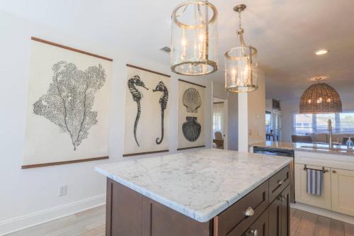 une cuisine avec des œuvres d'art sur les murs et un comptoir dans l'établissement Beachside Cottage, à Isle of Palms