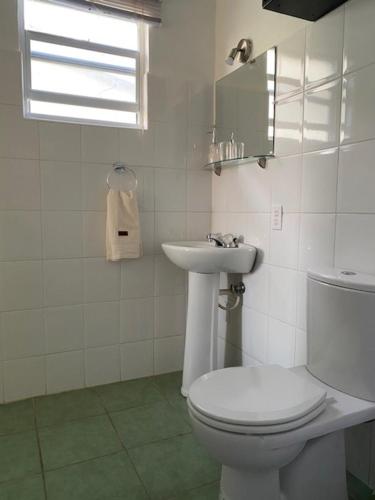 a bathroom with a white toilet and a sink at Blue Lagoon Apartment in Lagun